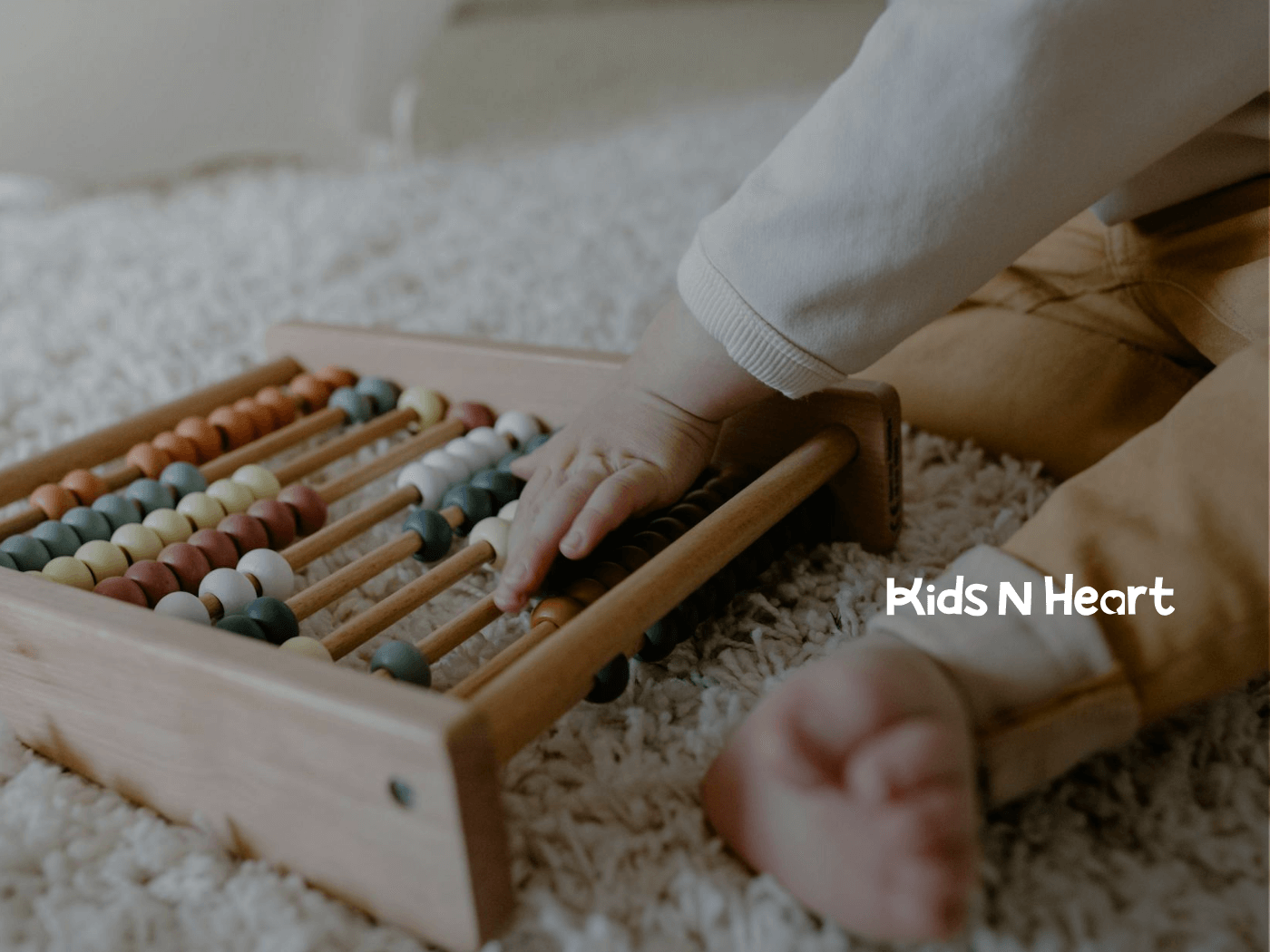 Autistic baby playing with wooden abacus on soft carpet during in-home ABA therapy in North Carolina.