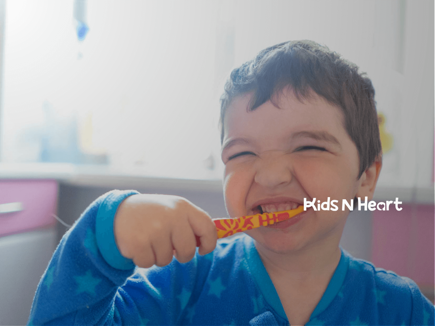 Autistic boy in blue pajamas brushing his teeth with a yellow and red toothbrush during in-home ABA therapy in NC.
