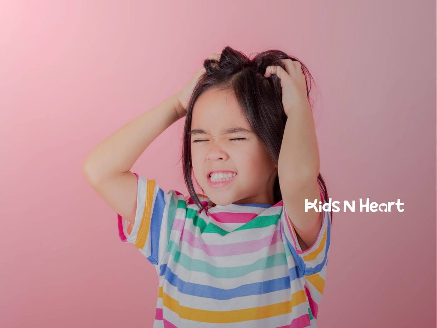 Young girl with autism pulling her hair and grimacing against a pink background.