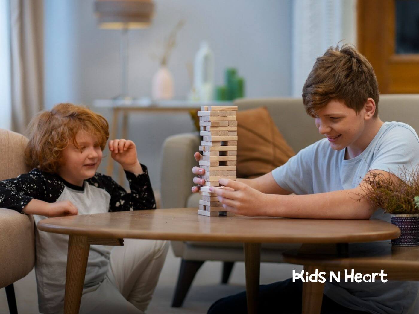 Two children with autism playing a game of Jenga together at a table.