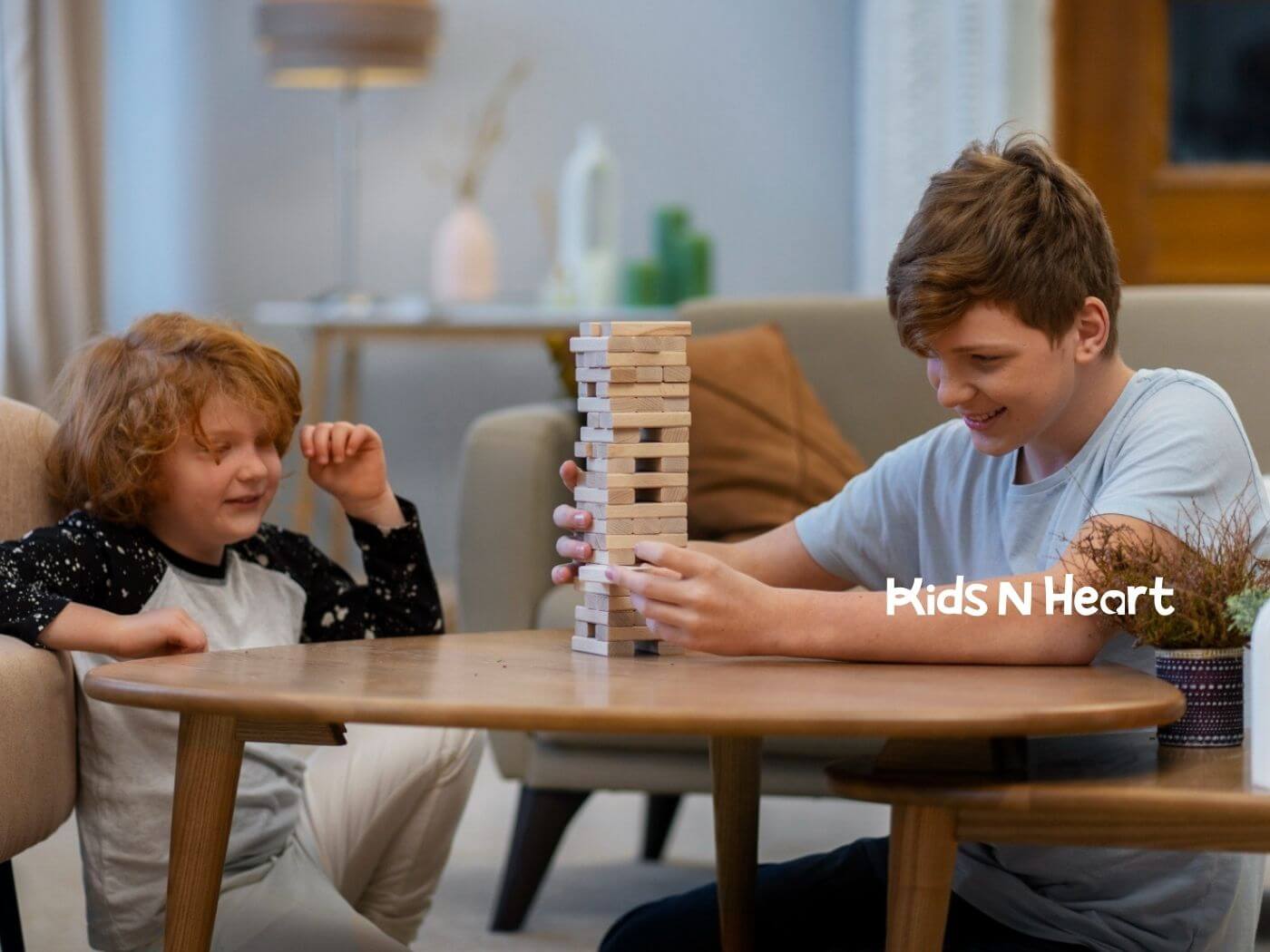 Two children with autism playing a game of Jenga together at a table.
