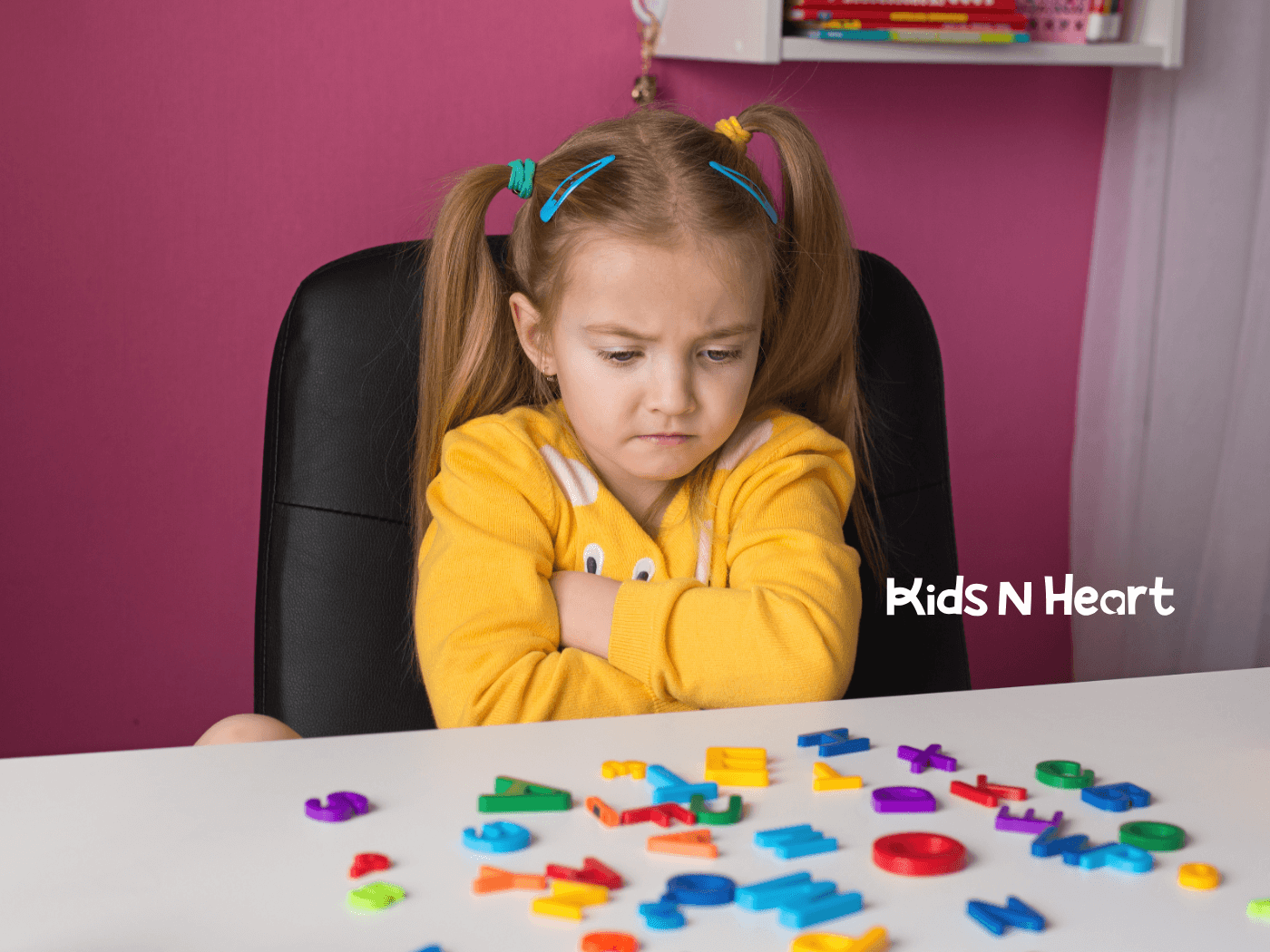 The autistic girl with crossed arms looking frustrated while sorting colorful alphabet magnets during ABA therapy.