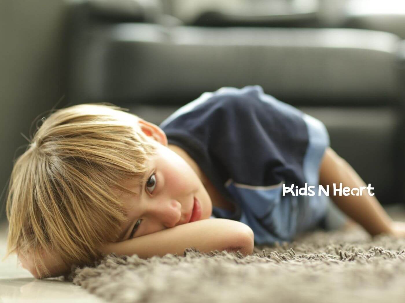 Child with autism lying on a carpet during ABA therapy session.