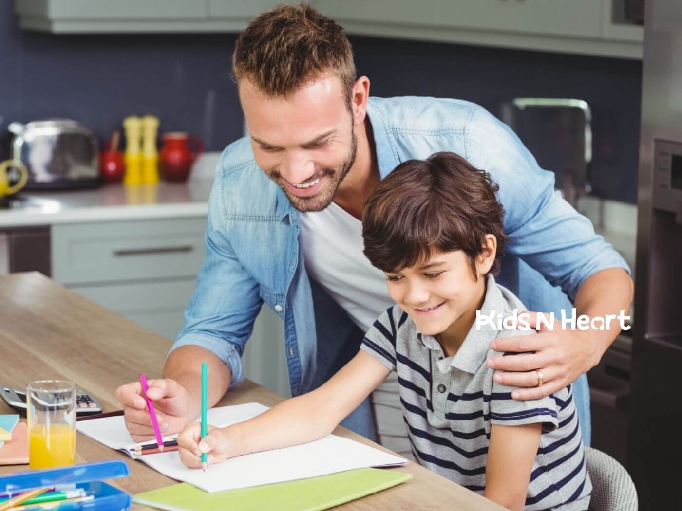 Smiling BCBA helping autistic child with drawing at a kitchen table during ABA therapy.