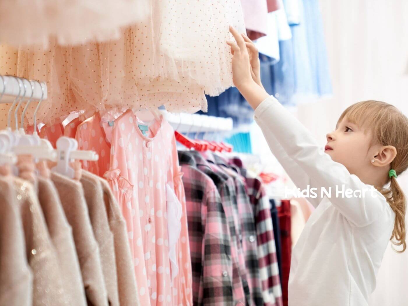 Young child with autism reaching for clothes on a rack while making a choice.
