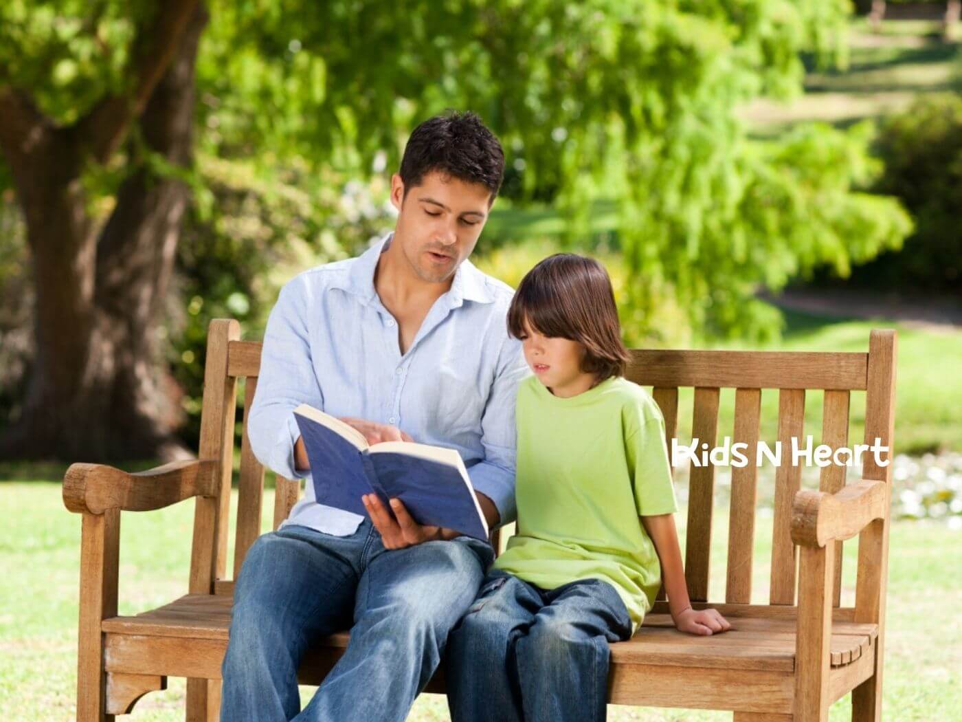 Male BCBA and child with autism sharing a reading moment outdoors during ABA therapy.
