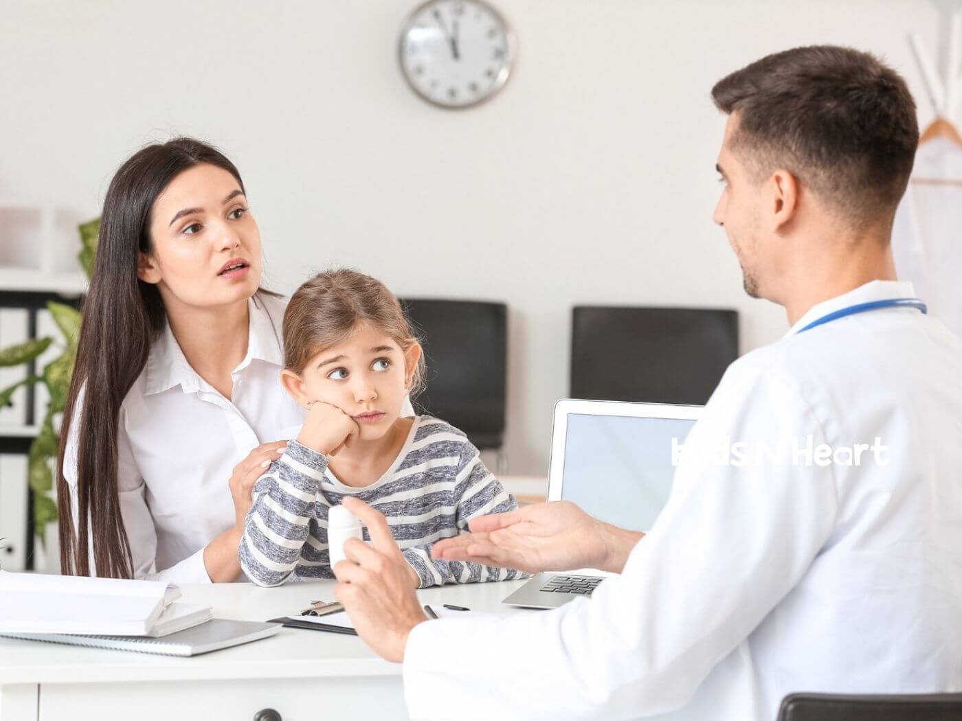 Worried mother and child speaking with a doctor at an office desk during an autism diagnosis process.