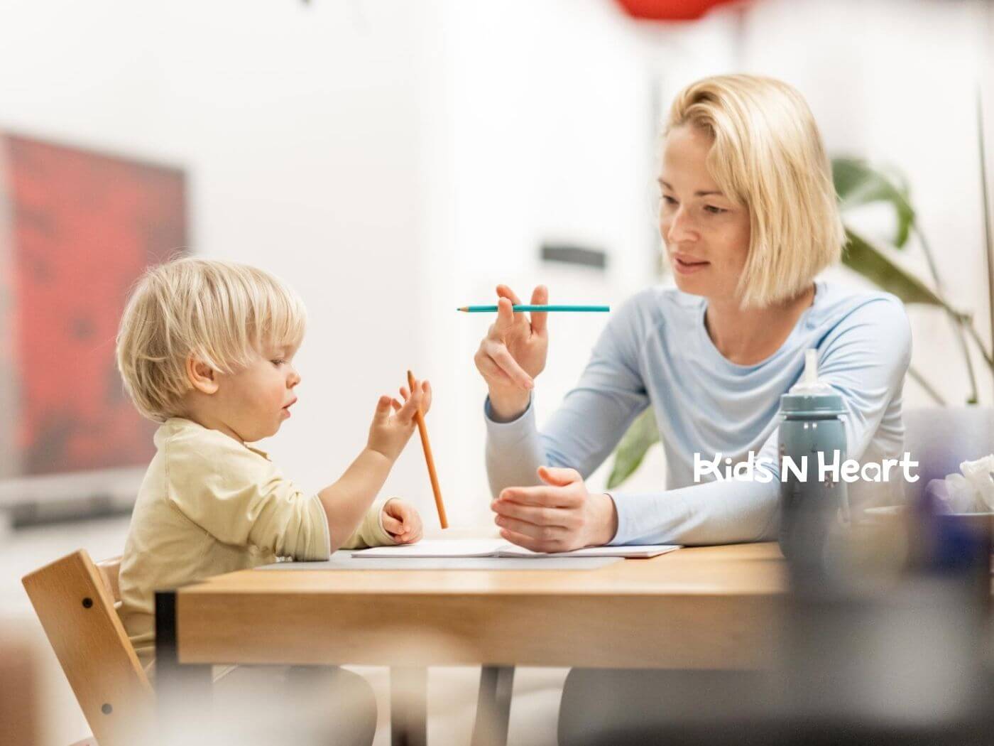BCBA working one-on-one with a young child at a table during ABA therapy.