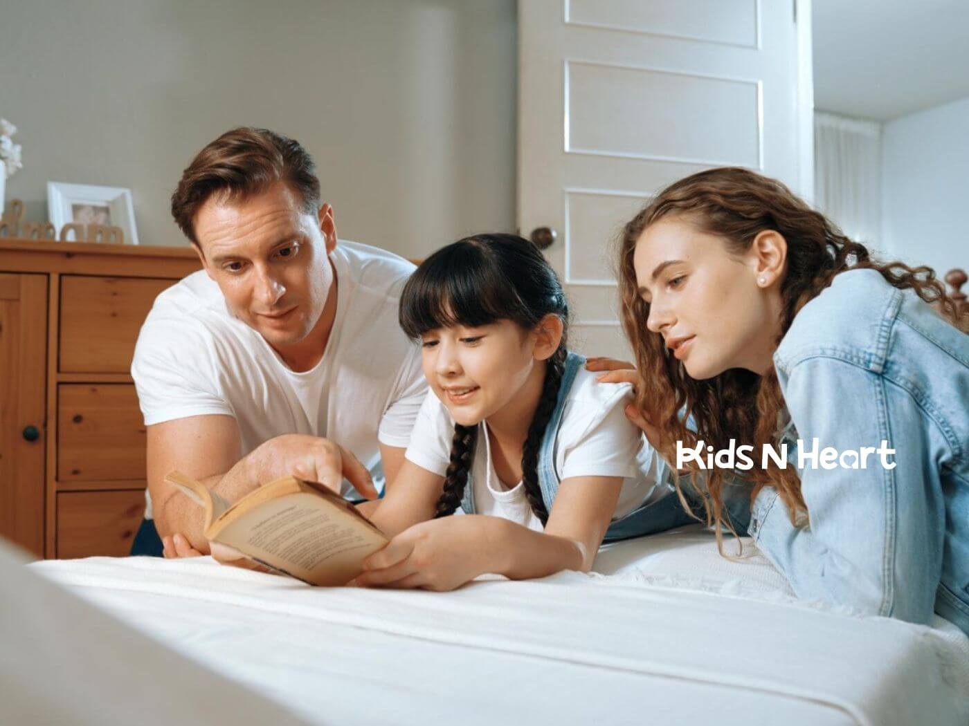 Parents reading a book with their daughter at home after in-home ABA therapy.