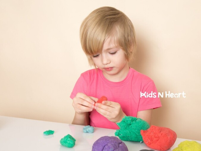 Autistic child playing with colorful modeling dough.