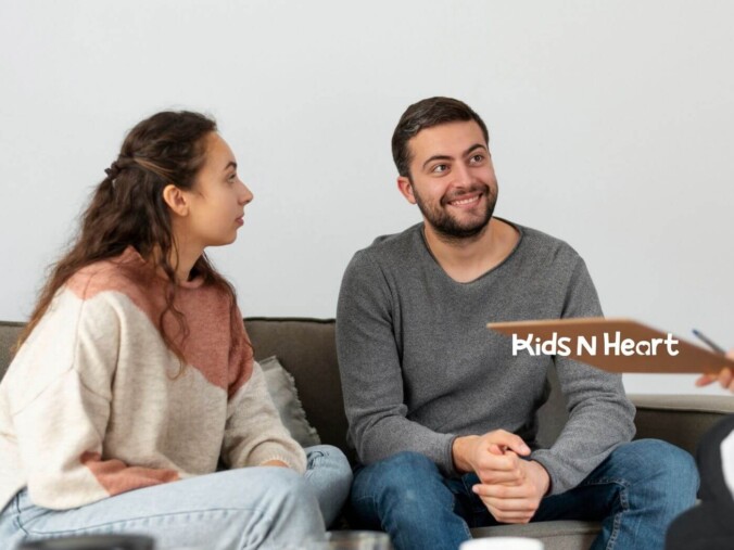 Couple sitting on a couch smiling during ABA parent training session.
