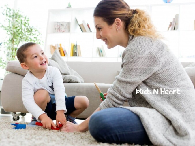 BCBA playing on the floor with a young child in a bright living room.