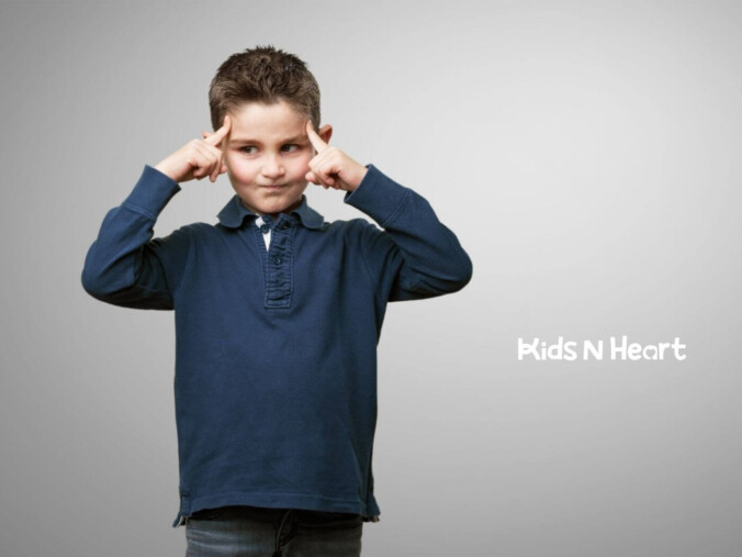 Boy with autism pointing to his temples thoughtfully.