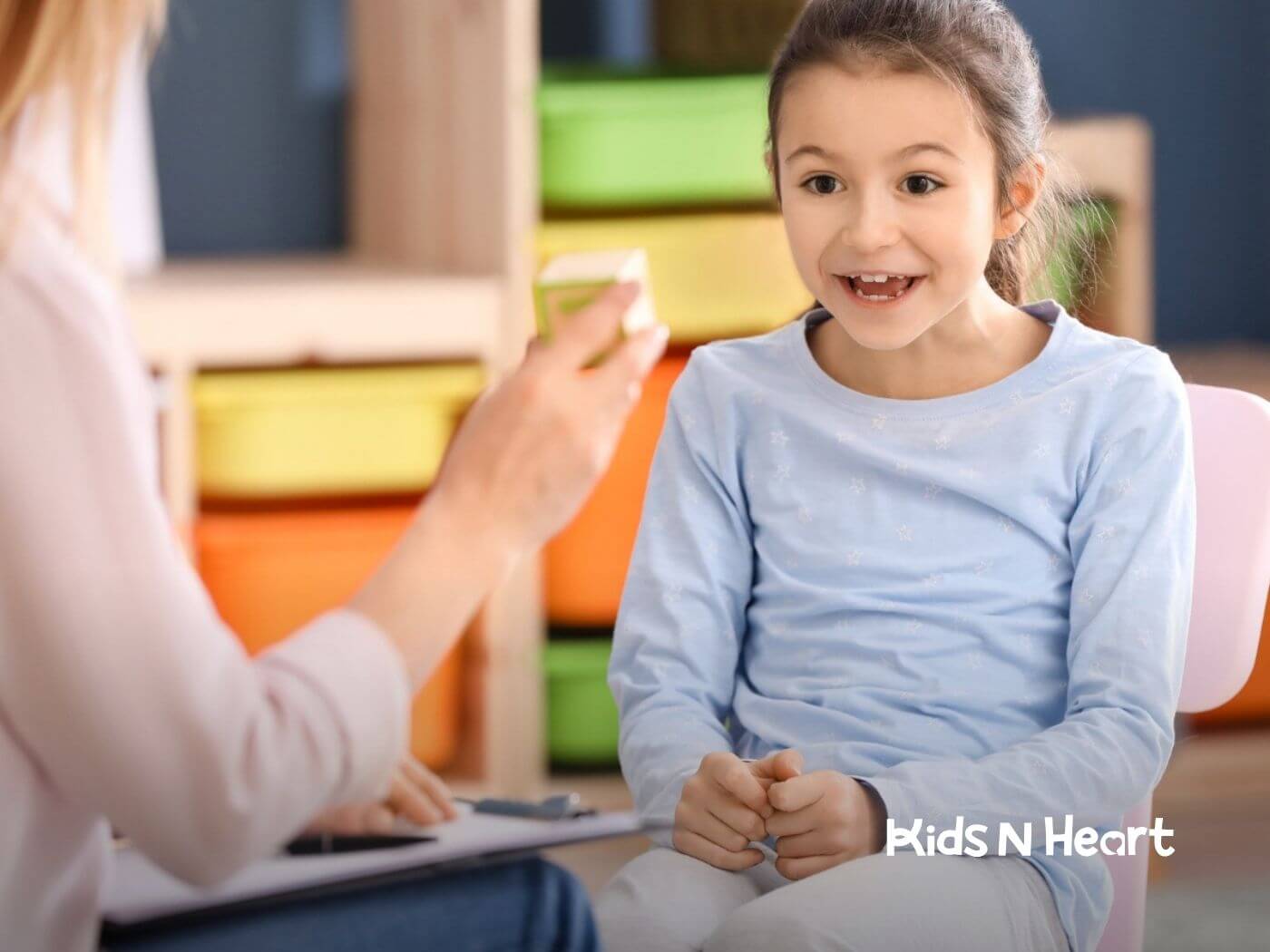 Child smiling and responding to an adult during a therapy session.
